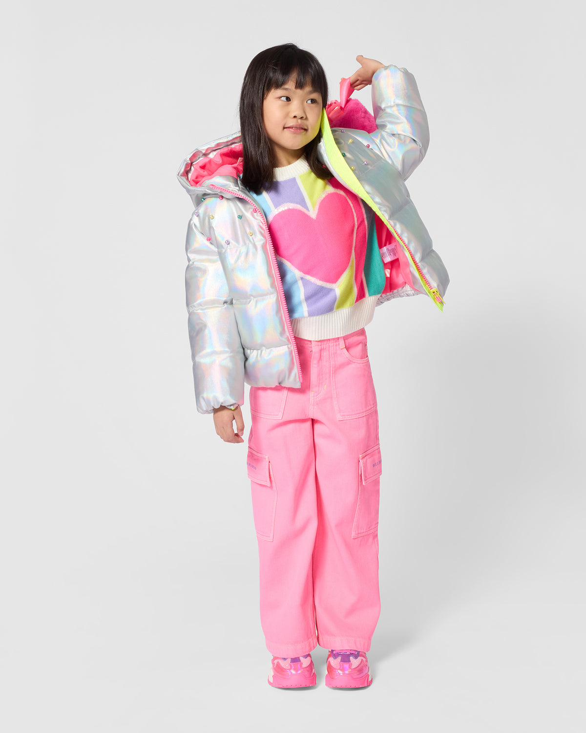 Billieblush girls rainbow stripe heart jumper styled with pink trousers and silver jacket