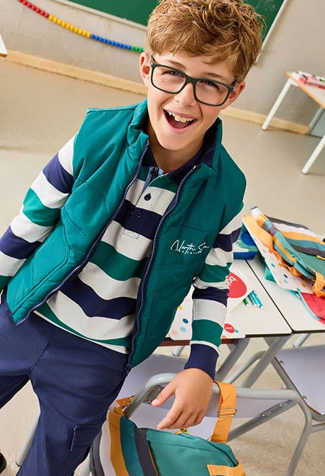 Boboli boys reversible gilet vest in green and navy styled over striped knit jumper.