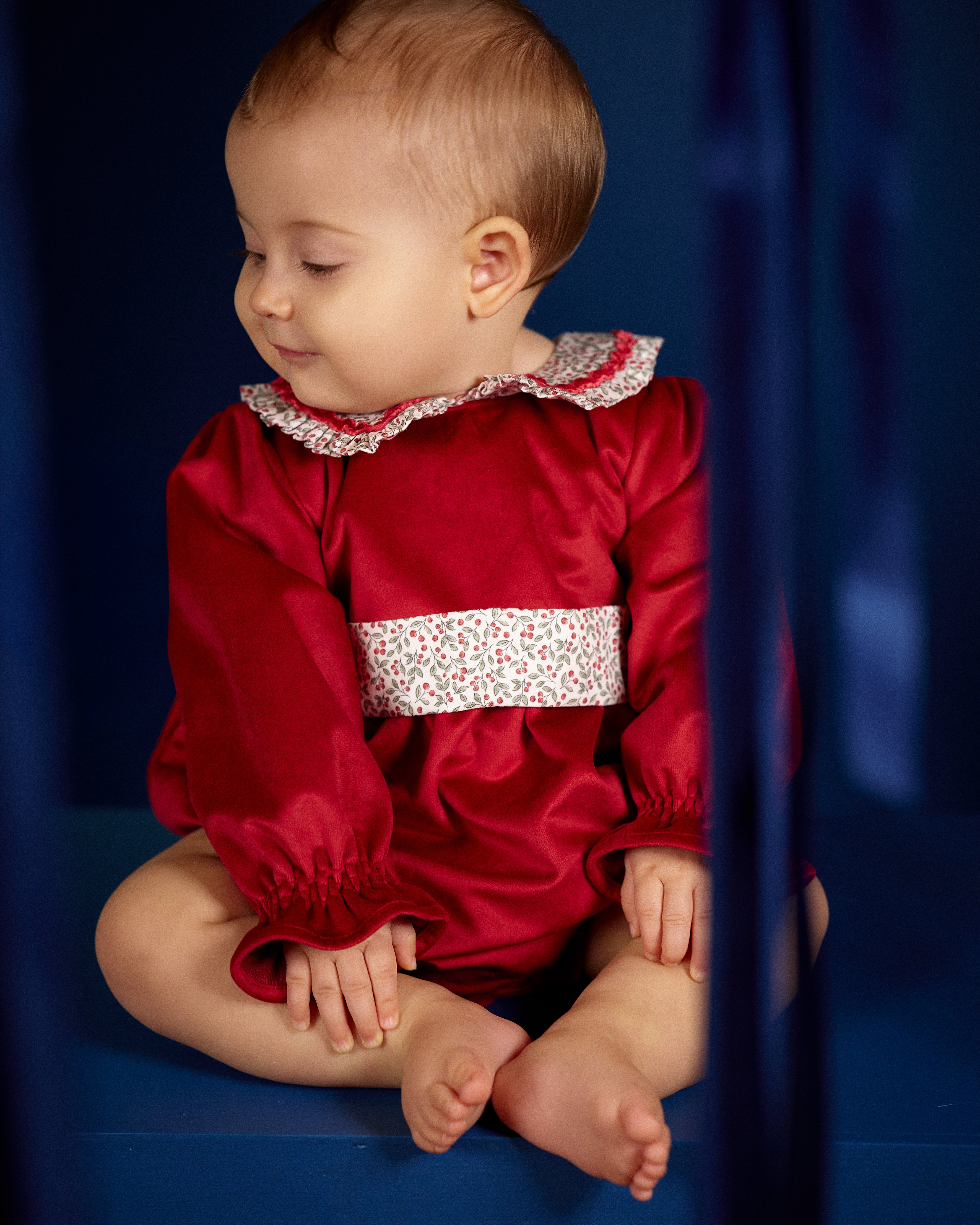 Baby girl wearing Deolinda Frosty red Christmas romper with floral collar