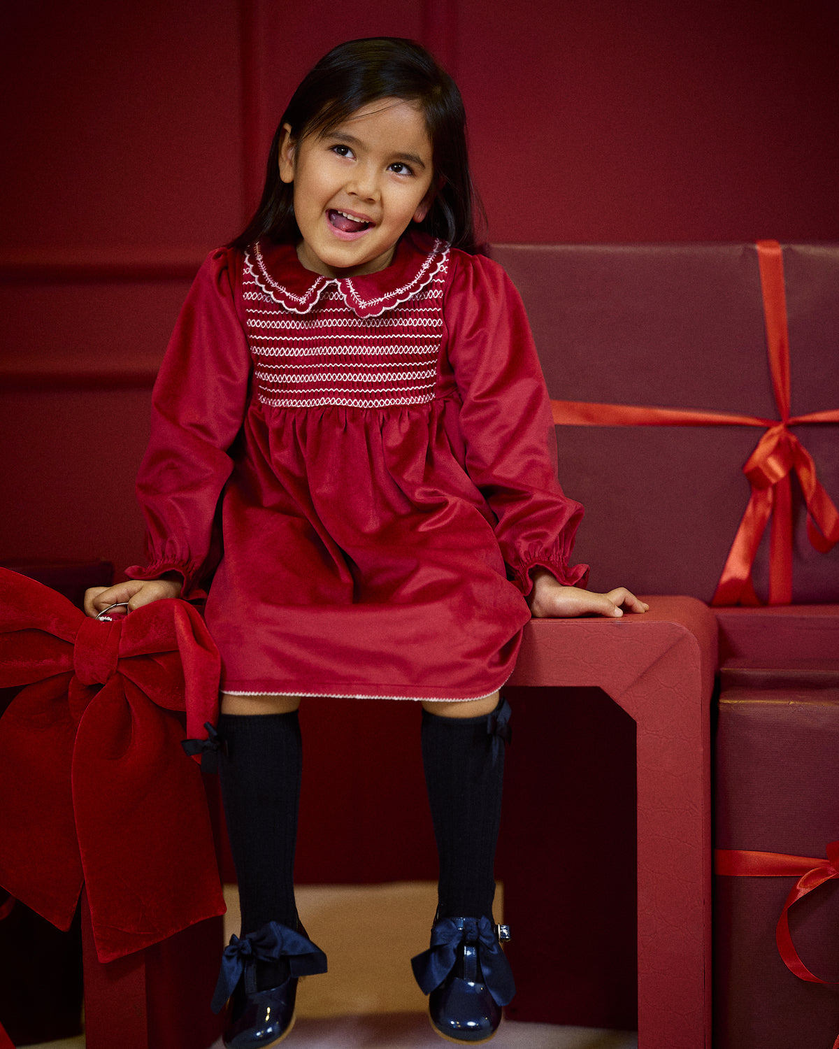 Girl wearing Deolinda Jolly red smocked Christmas party dress