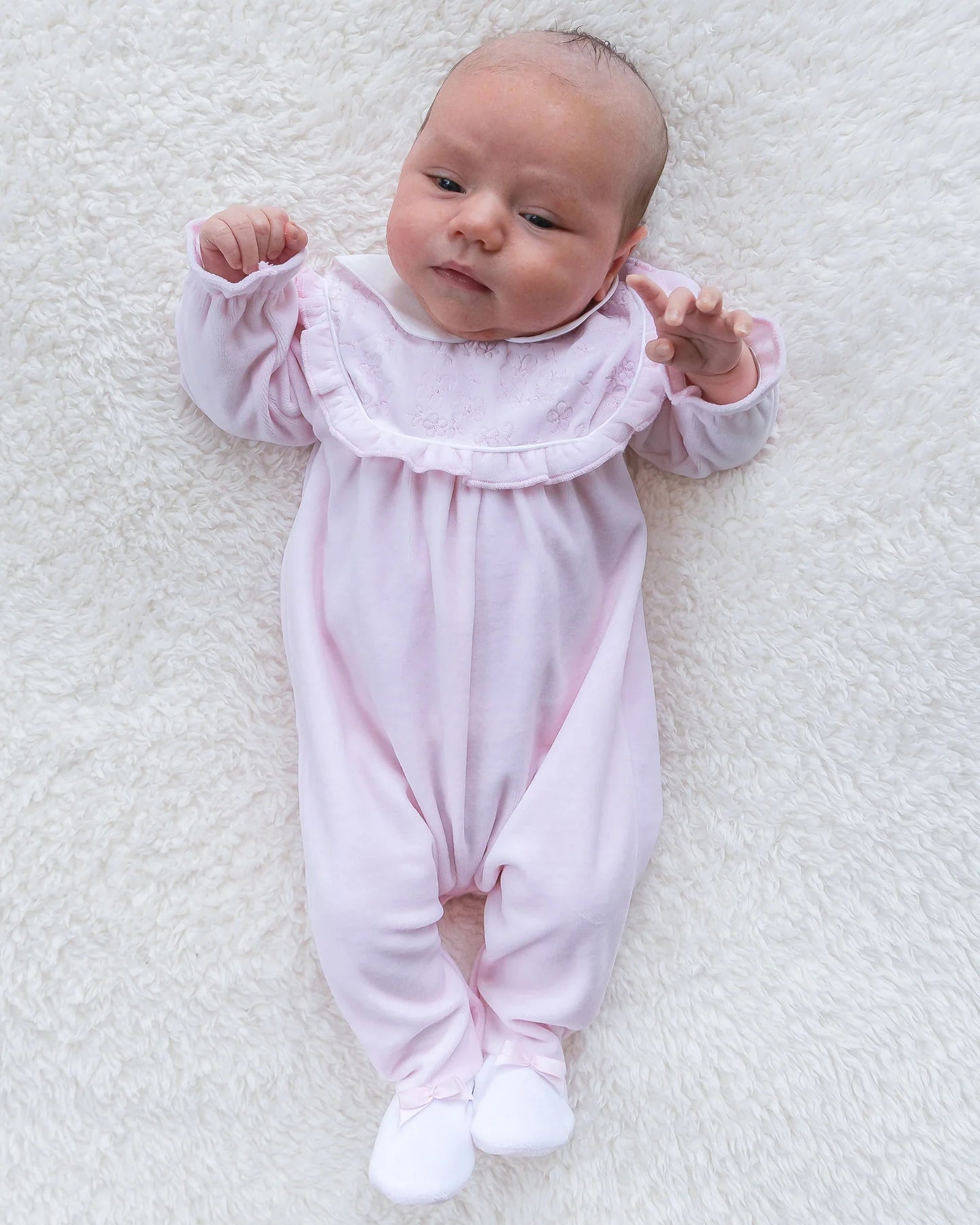 Baby girl wearing Emile et Rose Maddy pink velour babygrow lifestyle view