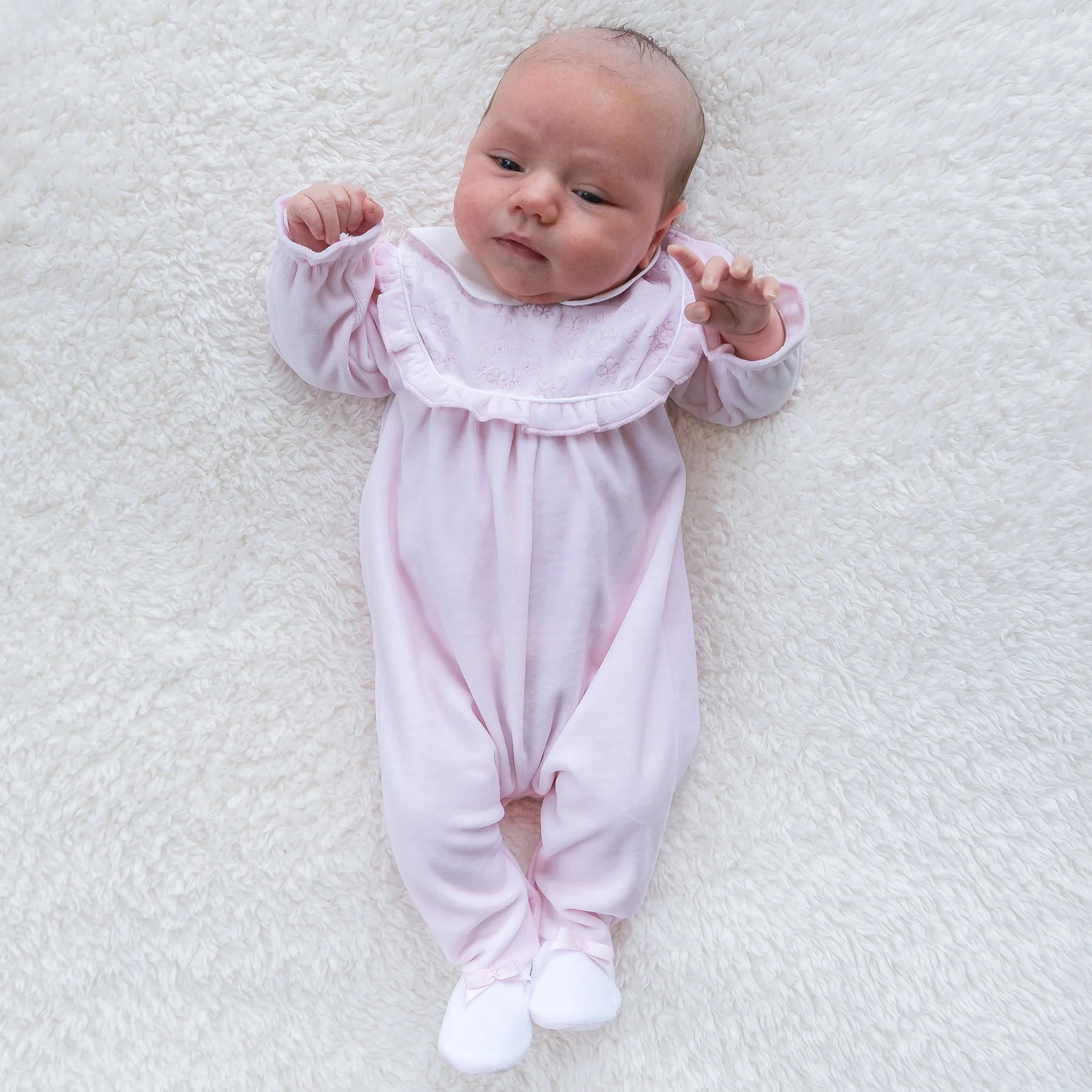 Baby girl wearing Emile et Rose Maddy pink velour babygrow lifestyle view