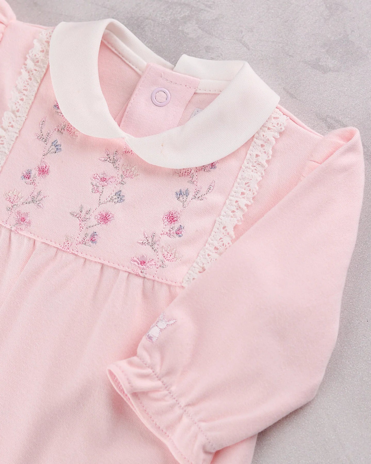 Baby girl wearing Emile et Rose Madeleine pale pink velour babygrow