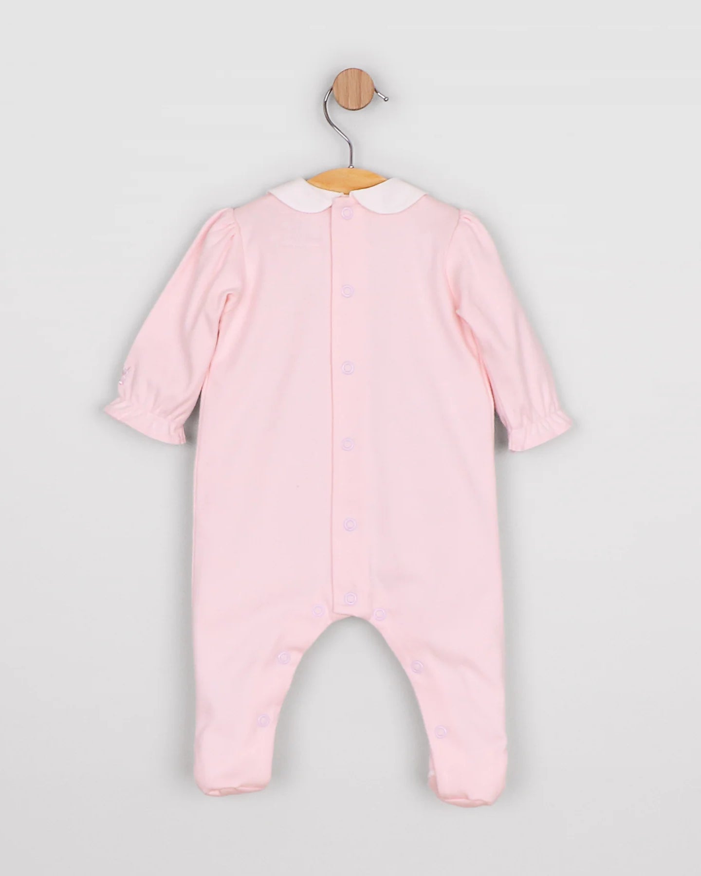 Baby girl in Emile et Rose Madeleine pink romper from the back