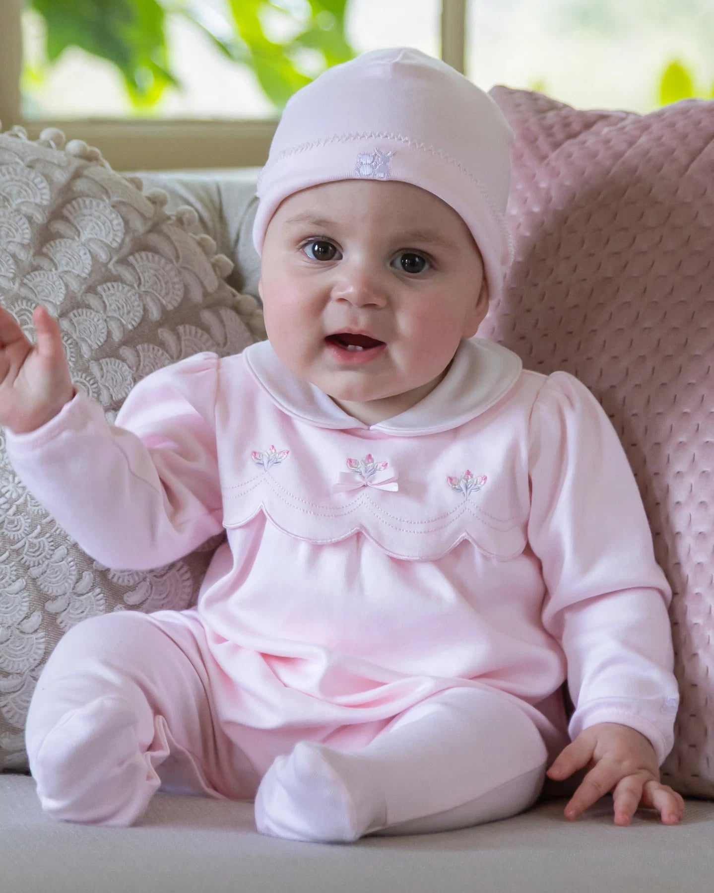 Baby girl wearing Emile et Rose Matilda pale pink romper and hat set