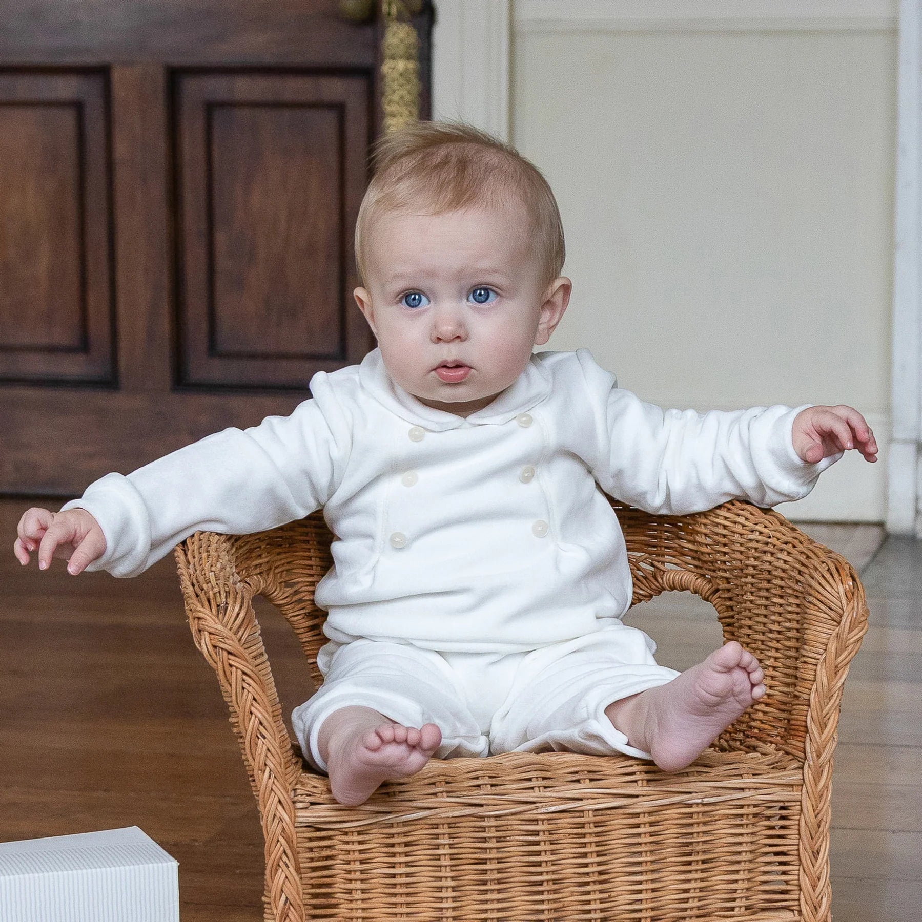 Baby boy wearing the Emile et Rose Marshall ivory velour romper while sitting