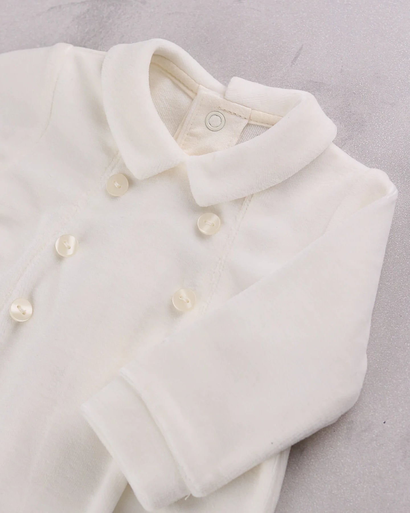 Close-up of the double-breasted buttons and collar on the Emile et Rose Marshall occasion romper