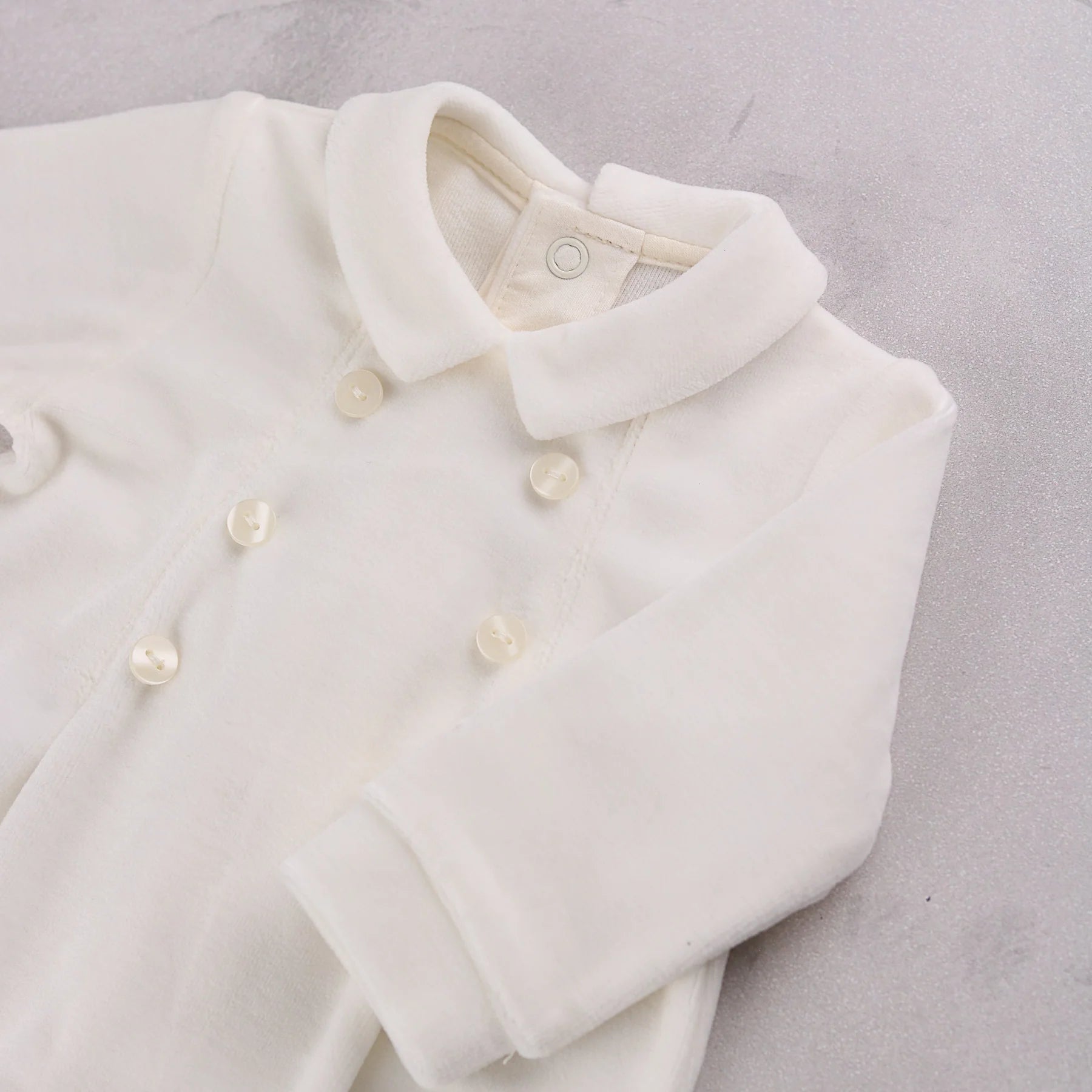 Close-up of the double-breasted buttons and collar on the Emile et Rose Marshall occasion romper