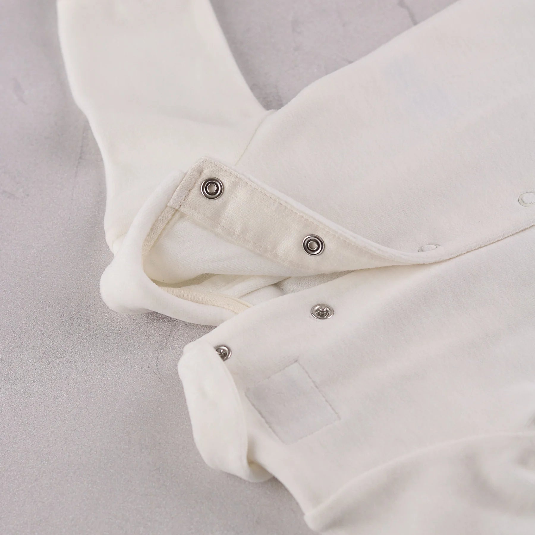 Close-up of the popper fastening on the Emile et Rose Marshall baby boys all in one occasion romper