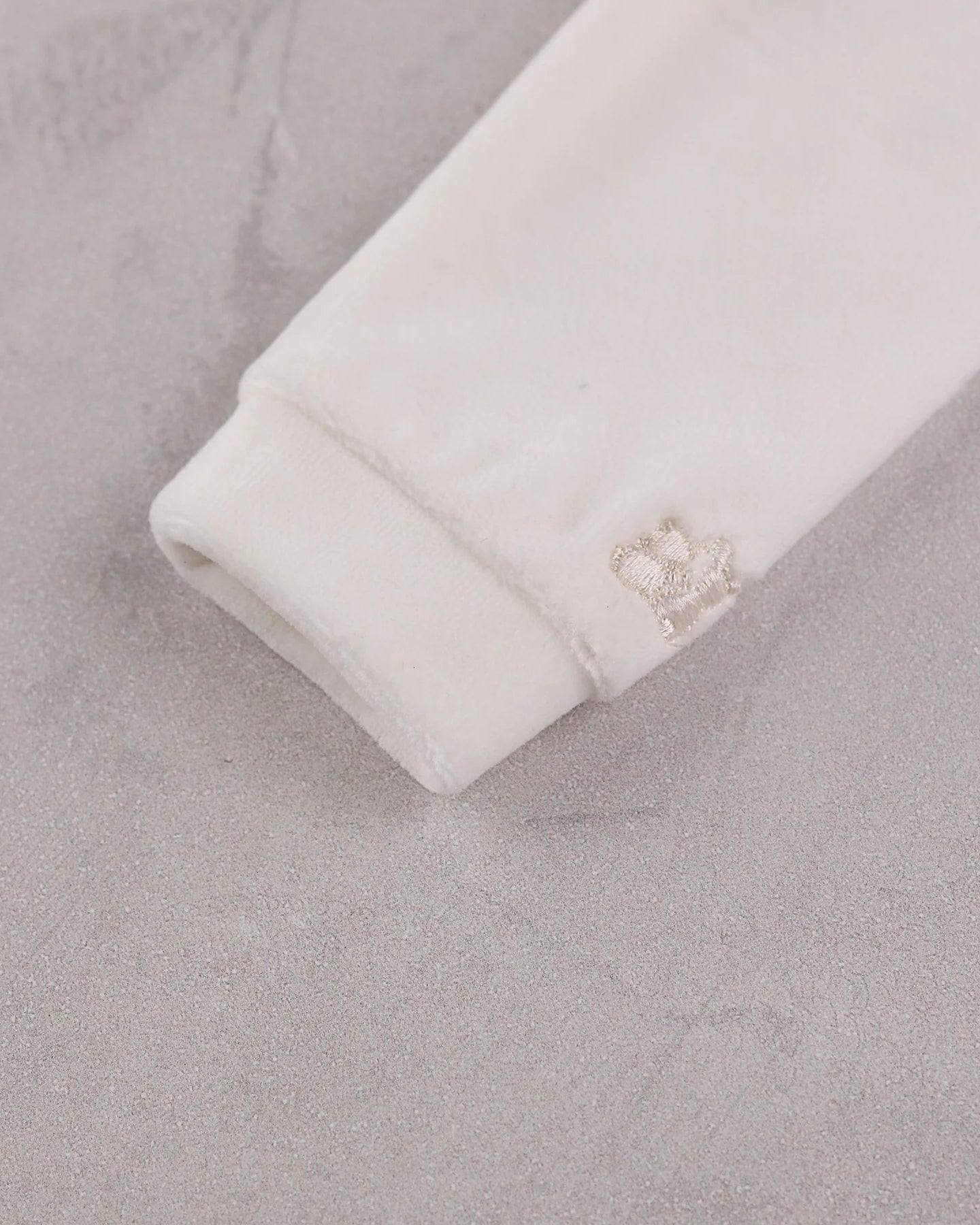 Close-up of the soft ivory velour sleeve cuff on the Emile et Rose Marshall romper