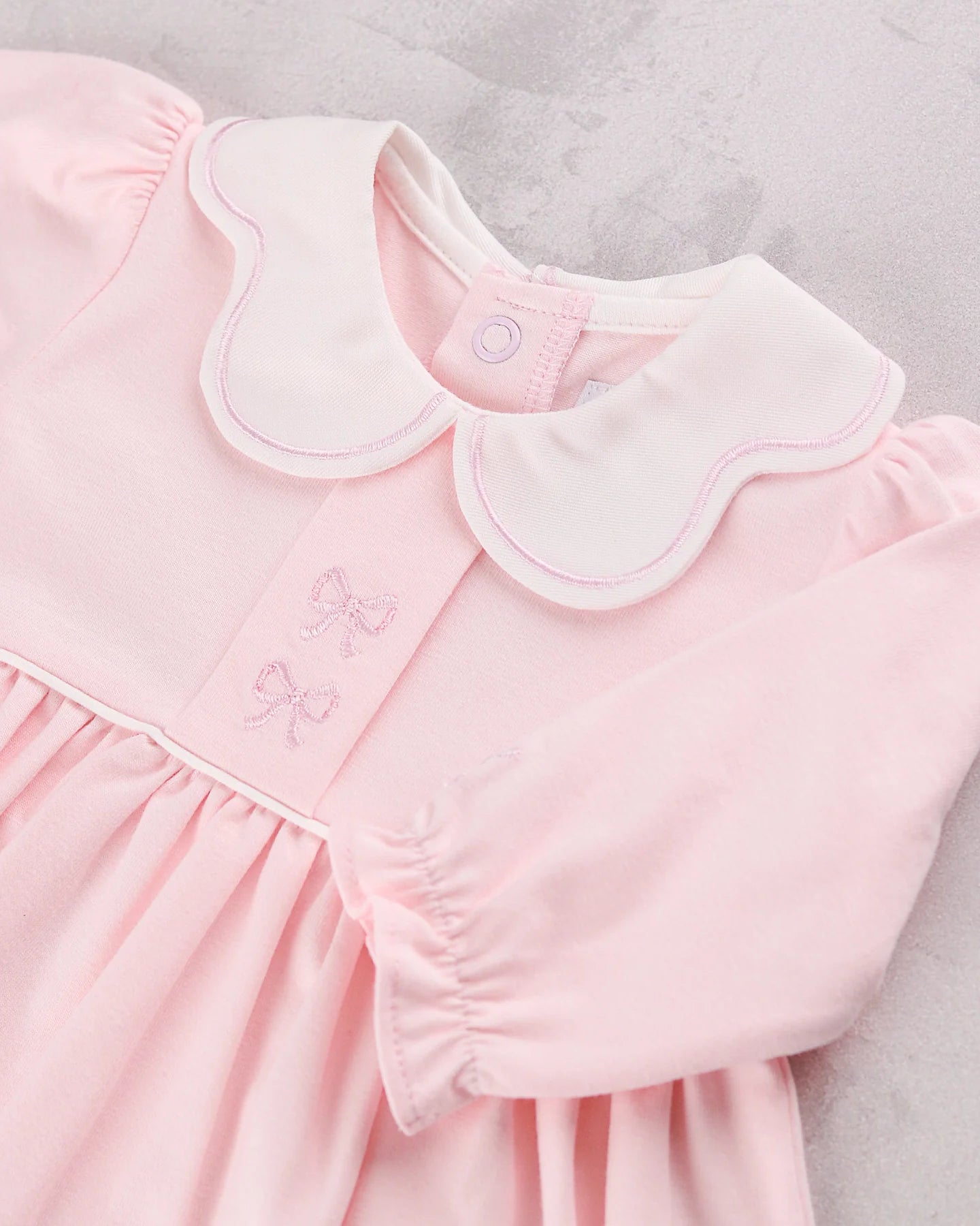 Close-up of the scalloped collar and bow embroidery on the Emile et Rose Maggie baby girls occasion dress