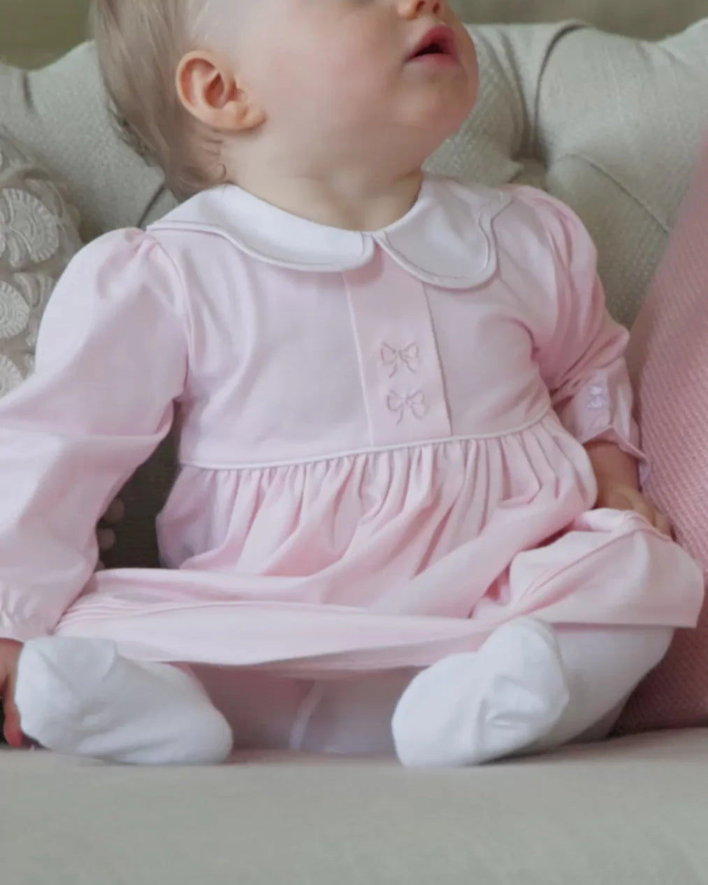 Baby girl wearing the Emile et Rose Maggie pale pink dress and tights