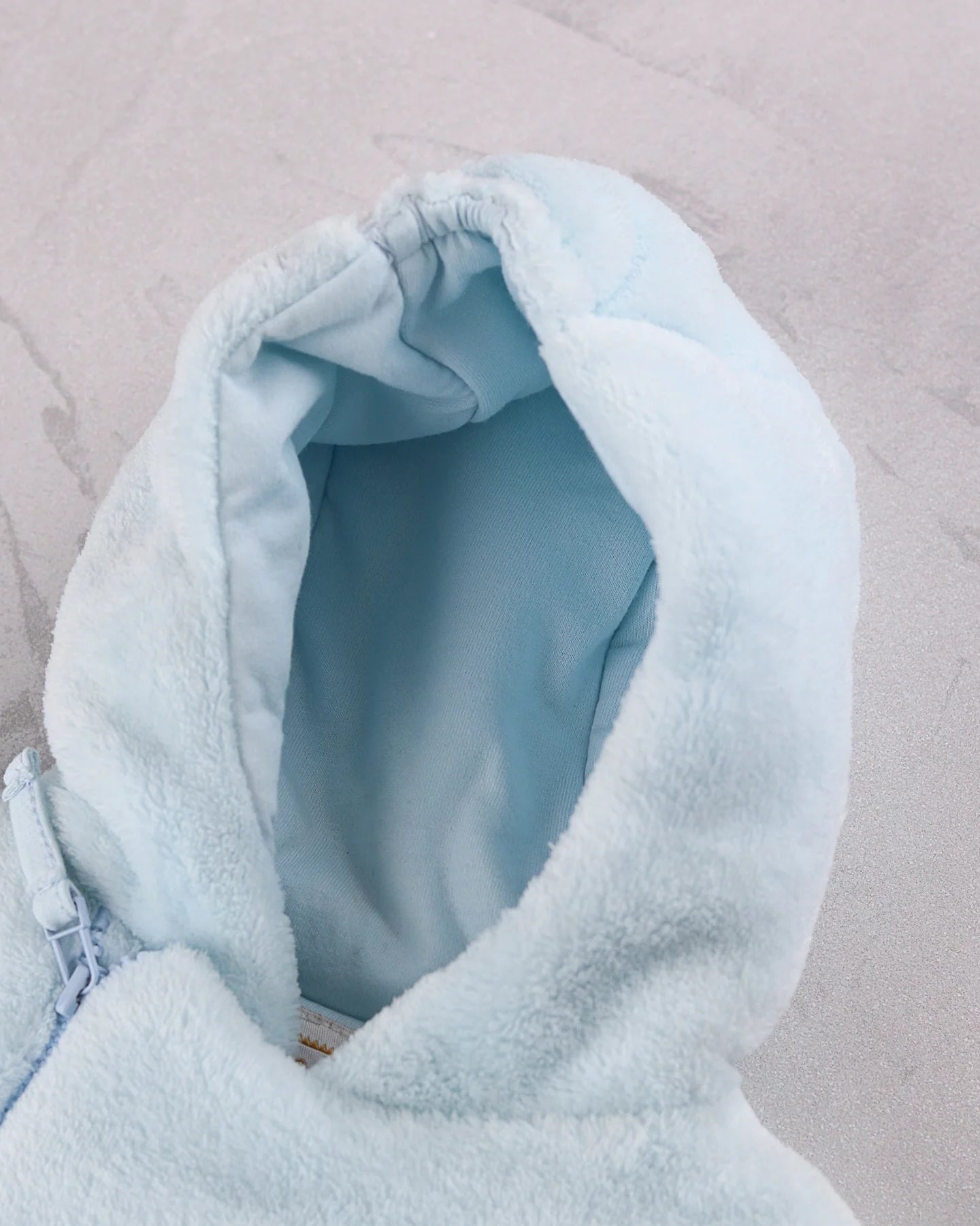 Baby sitting in the Emile et Rose Axel pale blue hooded fleece jacket