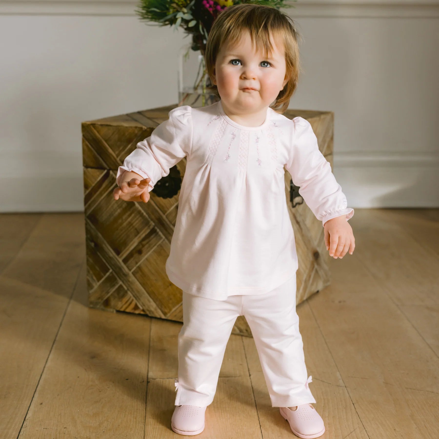 Baby girl indoors wearing Emile et Rose Kate pink cute two-piece outfit set.
