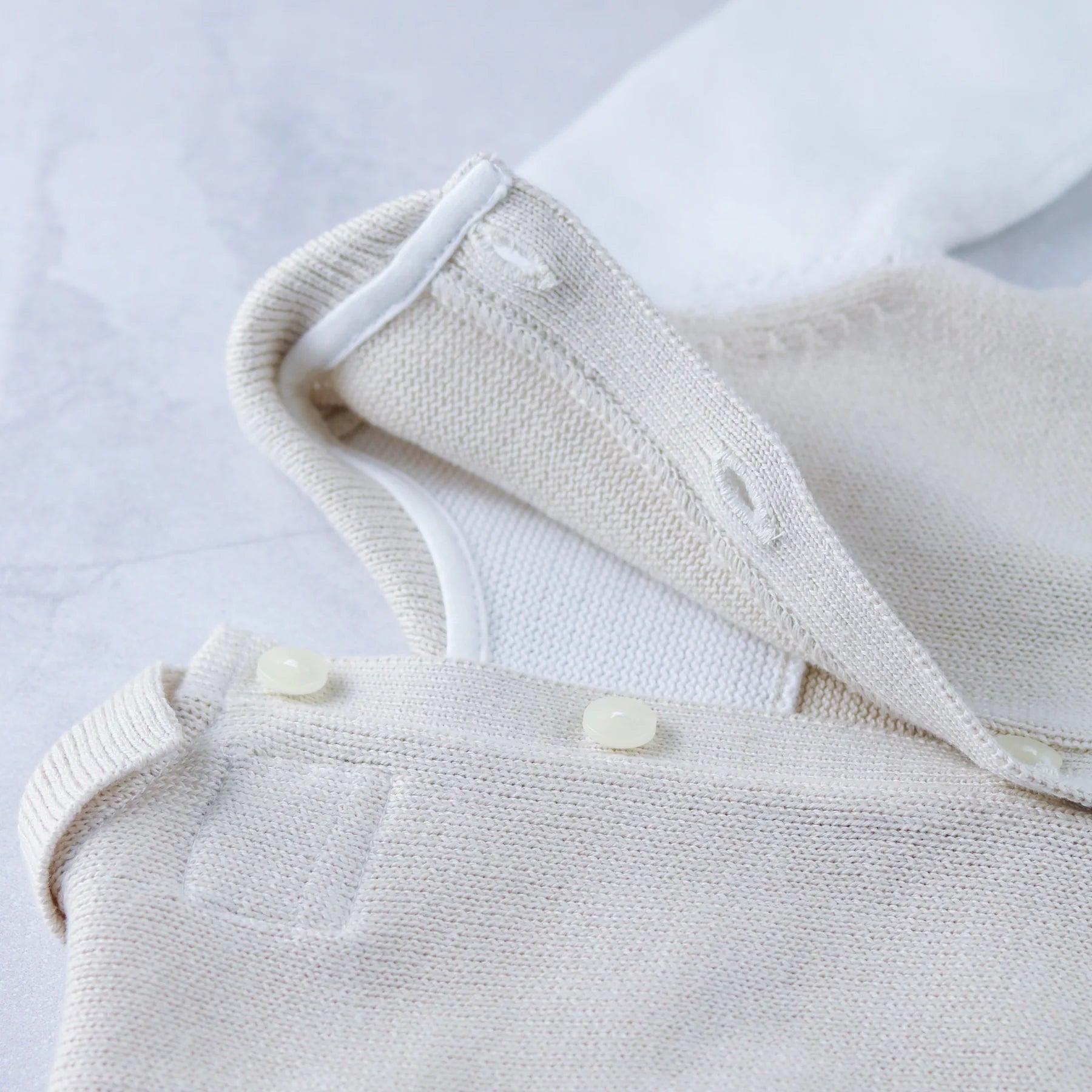 Back button detail on Emile et Rose Kenzie unisex knitted babygrow