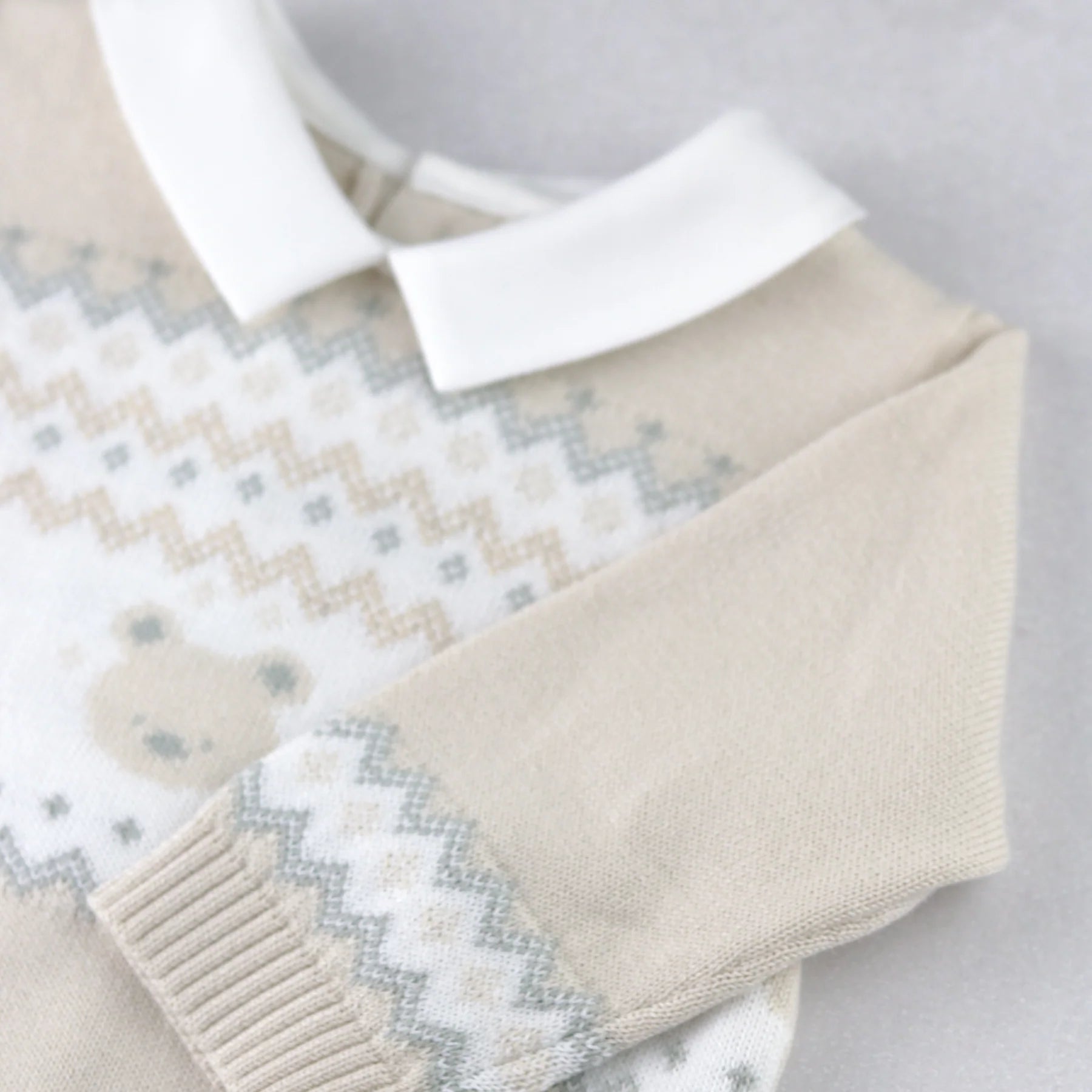 Close-up of Emile et Rose Kipling knitted teddy outfit fairisle sleeve detail.