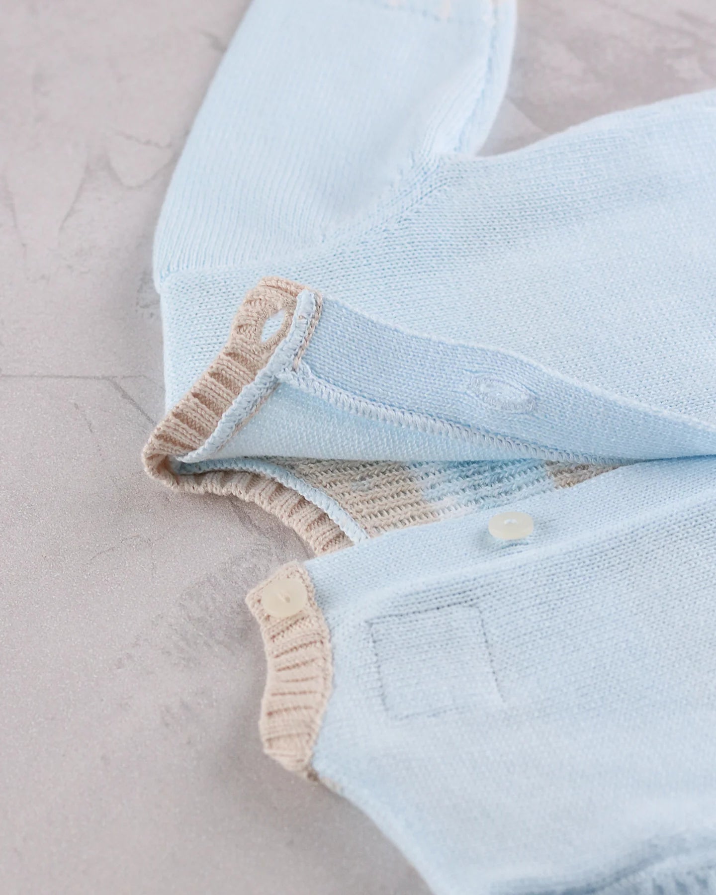 Close-up of Emile et Rose Martin knitted outfit set back button detail