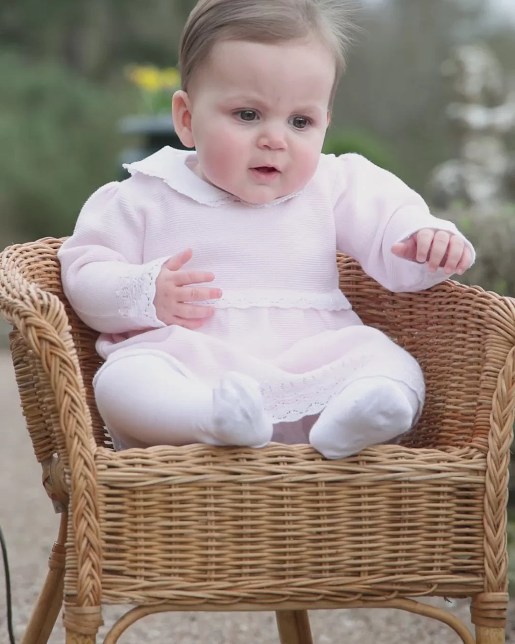 Baby girl wearing the Emile et Rose Millie pale pink knit dress and tights