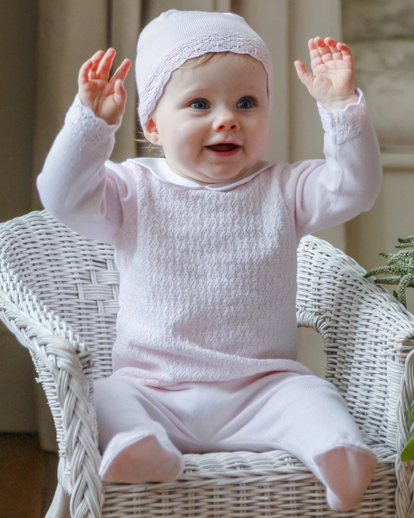 Baby wearing the Emile et Rose Minny pale pink baby girls knit outfit while sitting in a basket
