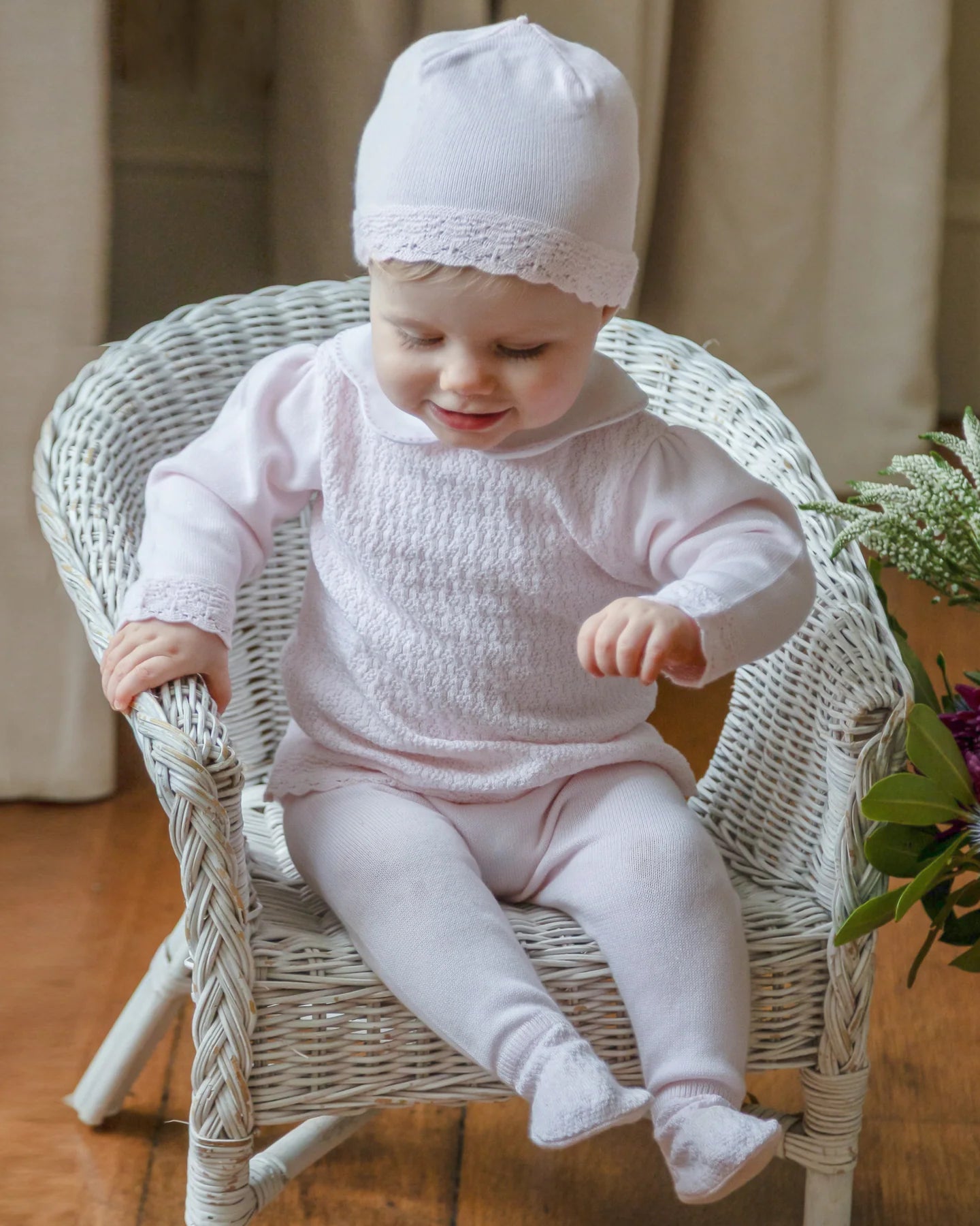 Baby wearing the Emile et Rose Minny pale pink baby girls knit outfit set and matching hat