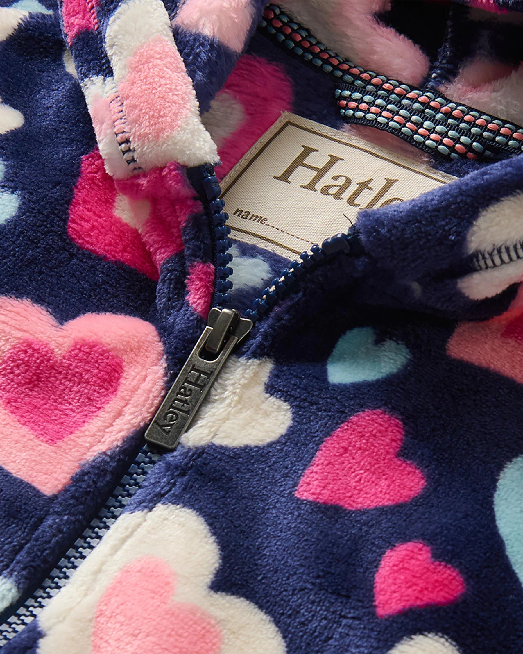 Hatley Girls Bunches of Hearts fleece zip-up hoodie close-up showing soft fleece and branded zip detail