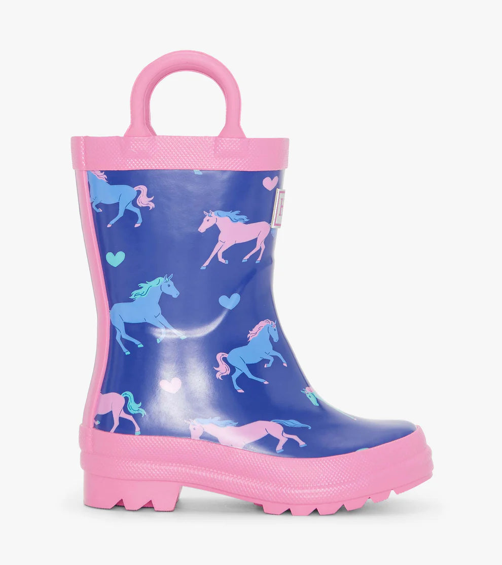 Side profile of navy Hatley girls wellies with pastel pink horse print