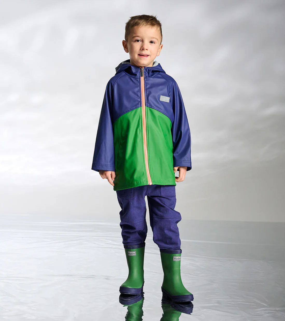 Hatley kids green waterproof wellies worn with rainwear