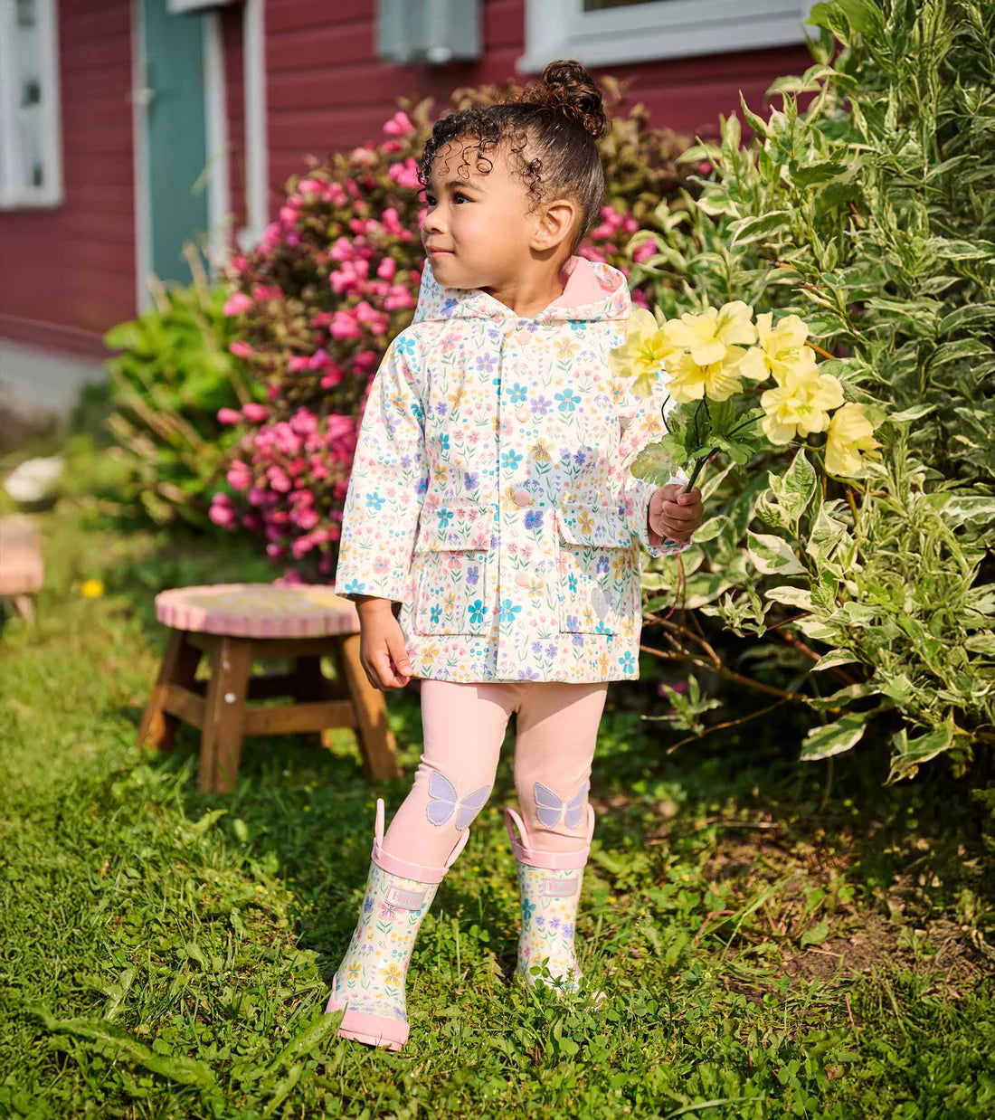 Hatley girls waterproof floral raincoat lifestyle image with matching boots
