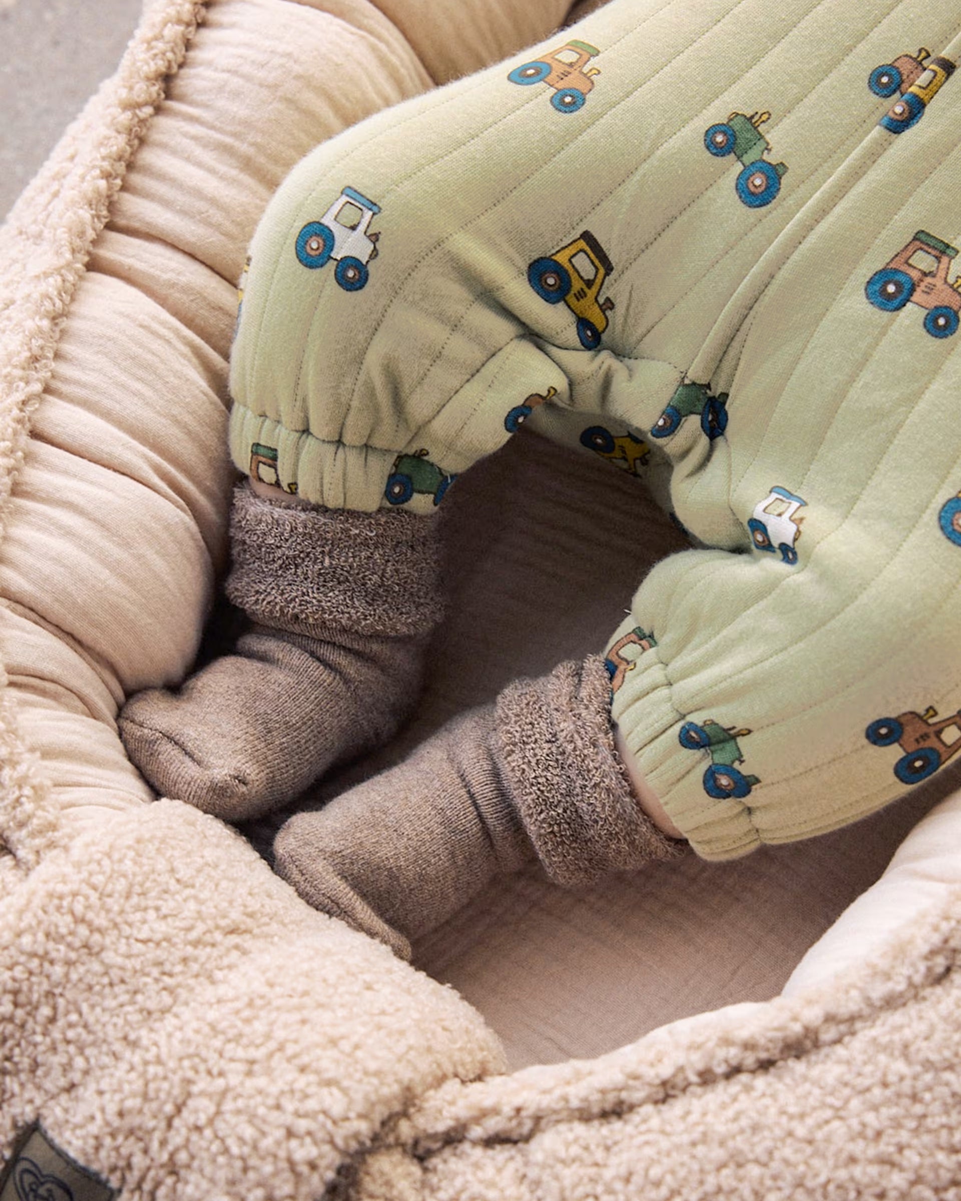 Close-up of Mayoral green tractor print baby dungarees with elasticated ankles