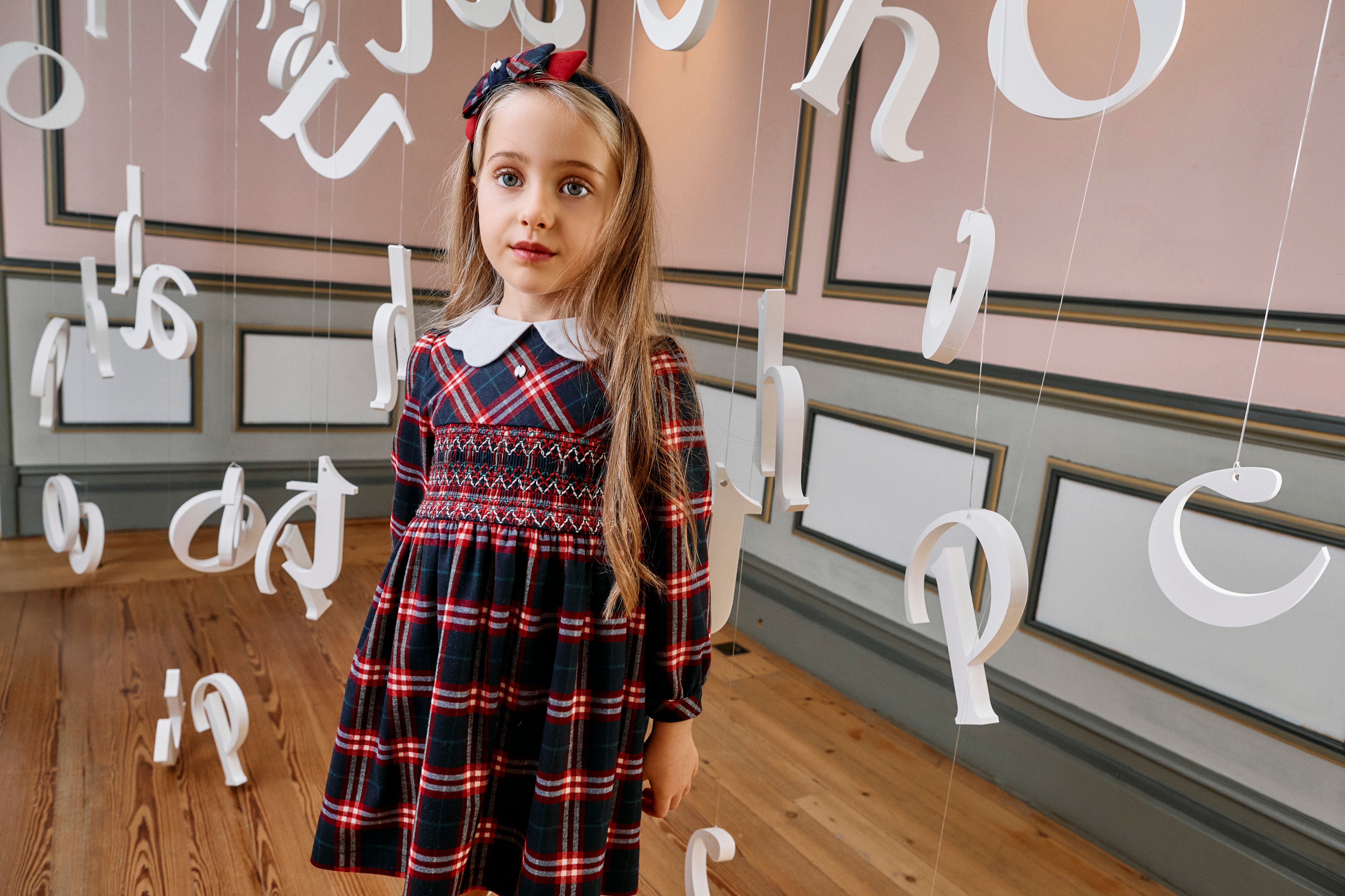 Girl wearing Patachou Balmoral red and navy tartan smocked dress