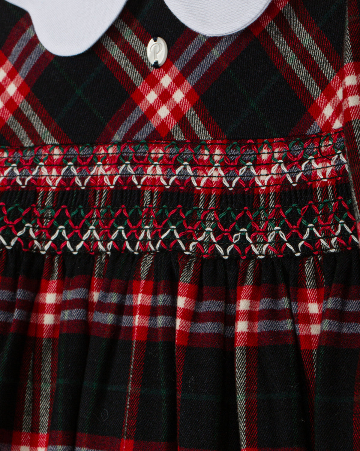 Close-up of Patachou Balmoral tartan dress with detailed smocked bodice