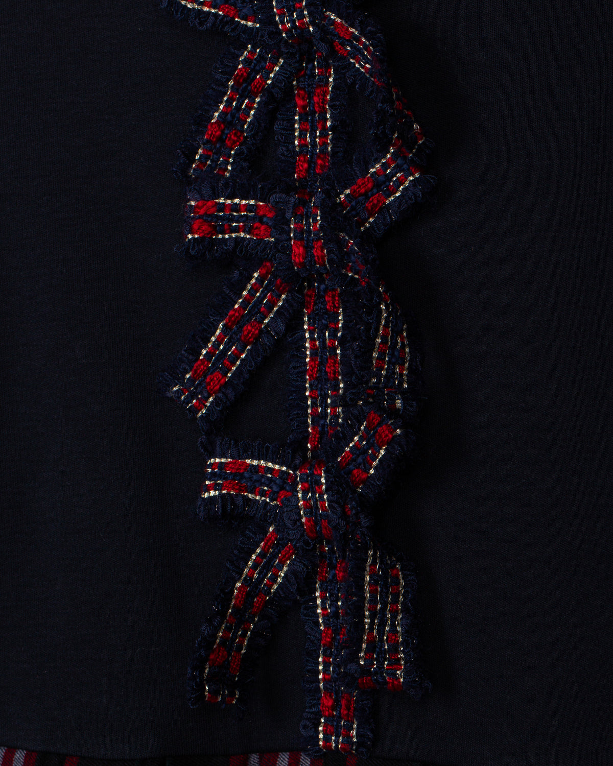 Close-up of Patachou navy Christmas dress with red tartan bow details