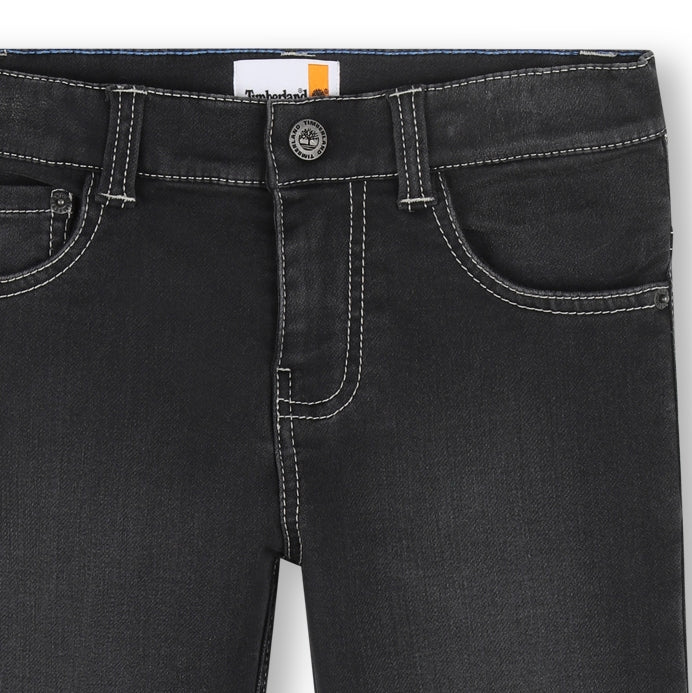 Close-up of Timberland boys black jeans showing waistband, button fastening and contrast stitching