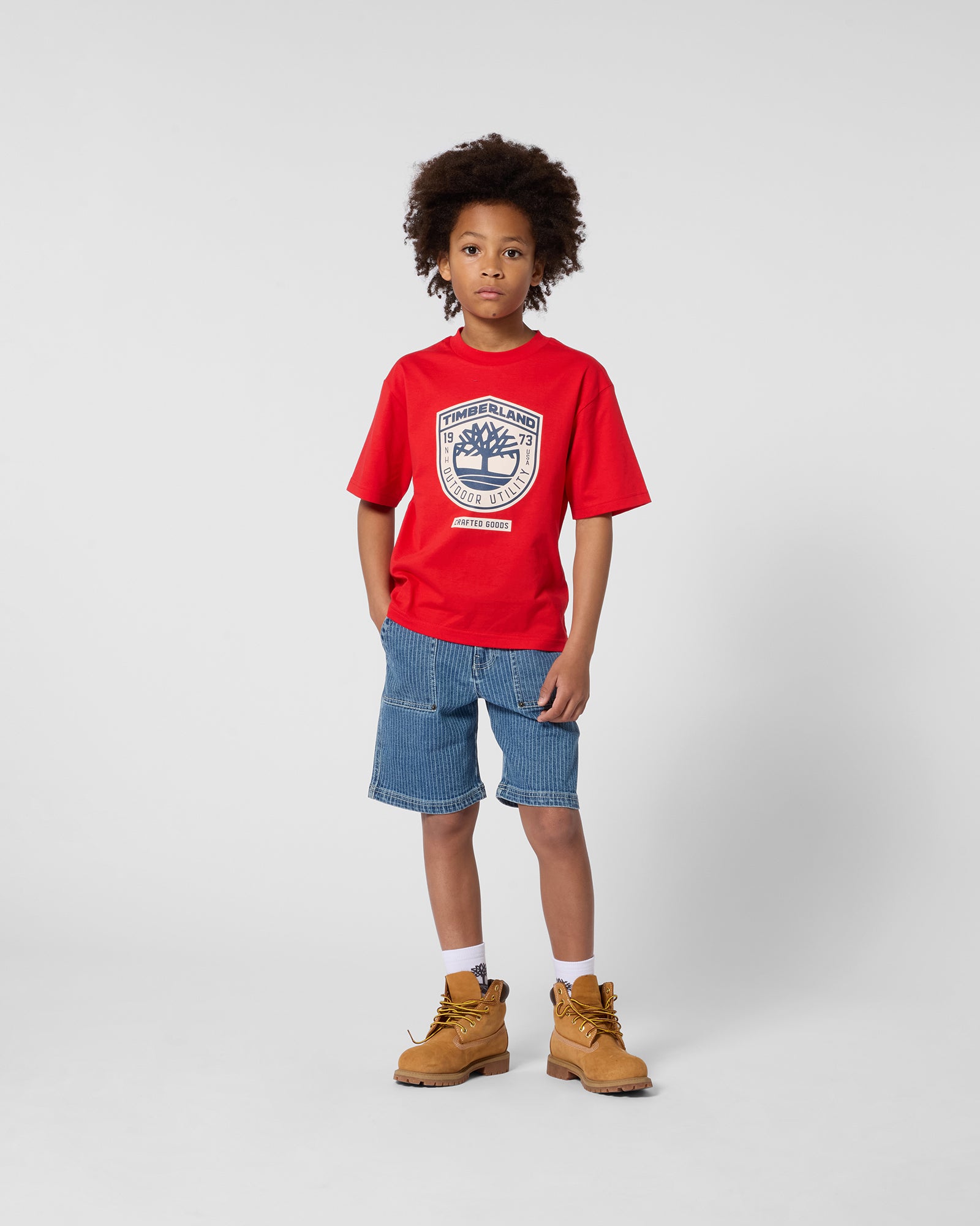Timberland boys red T-shirt styled with denim shorts
