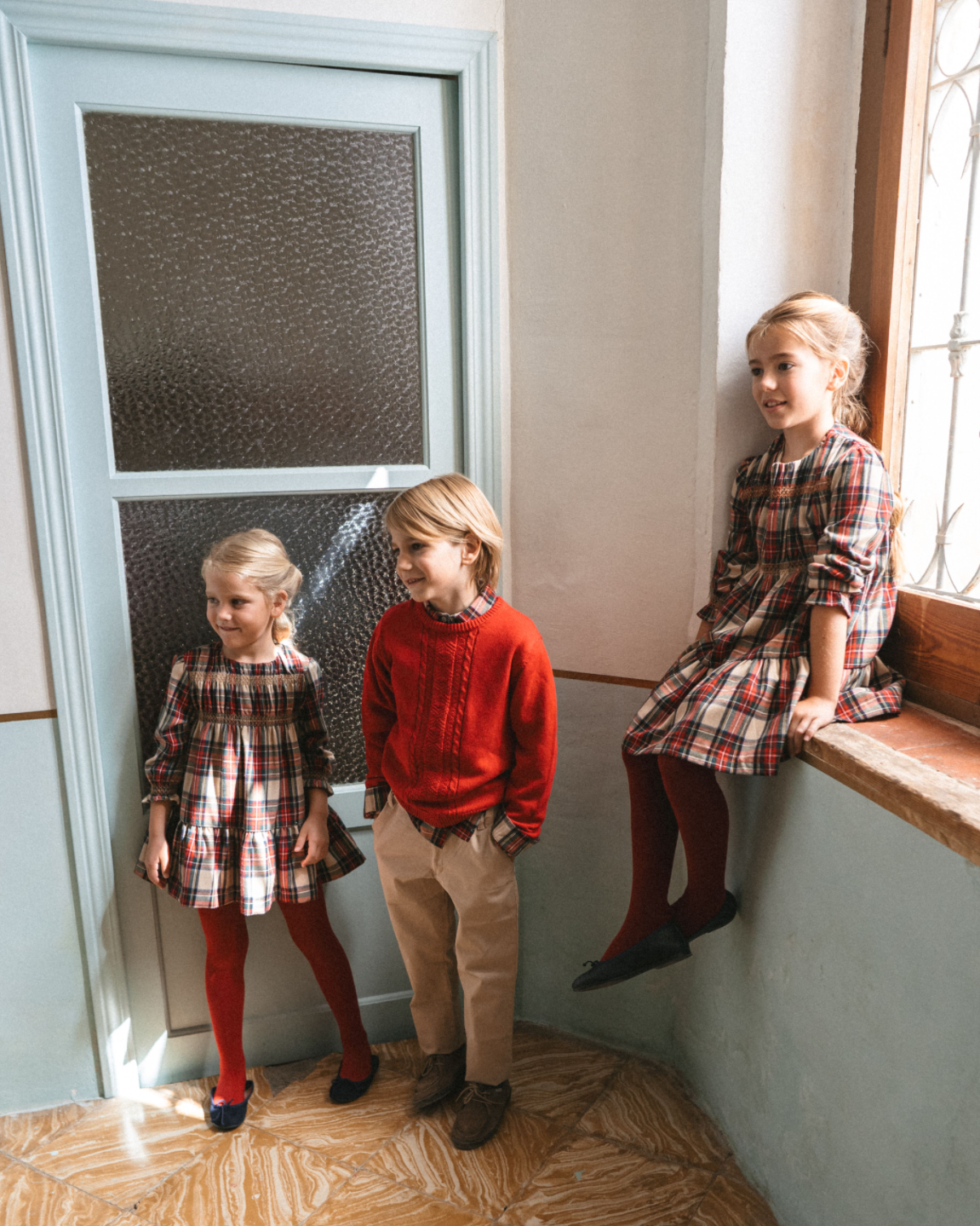 Boy wearing Tutto Piccolo red jumper and tartan shirt Christmas outfit