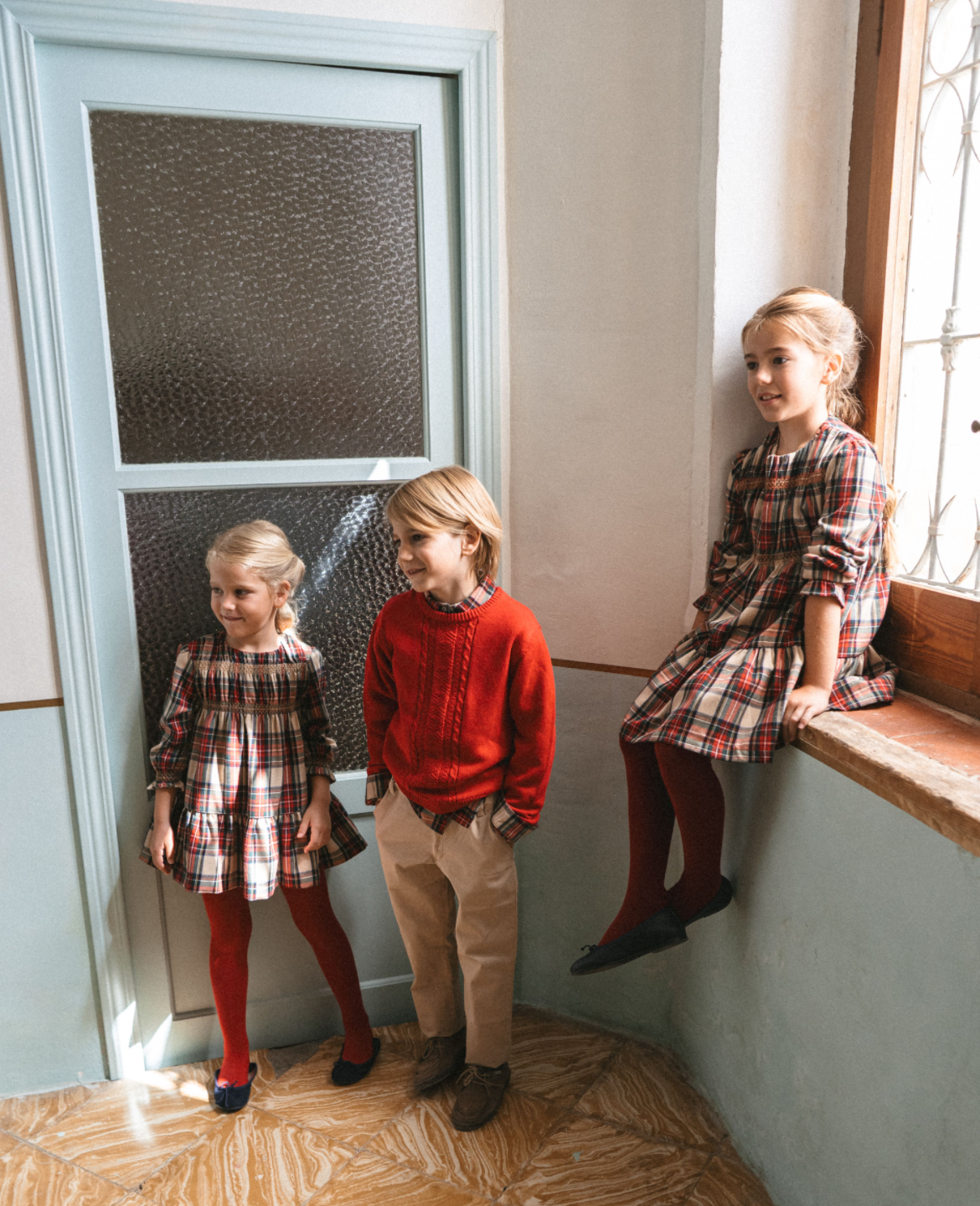 Boy wearing Tutto Piccolo red jumper and tartan shirt Christmas outfit