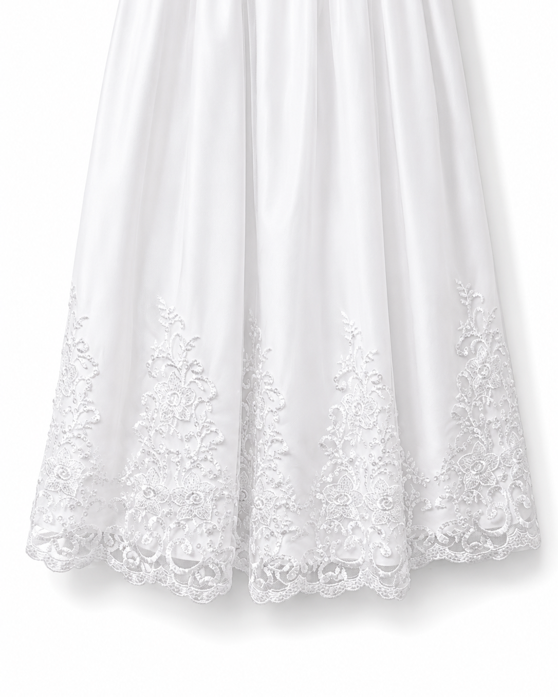 Close-up of the ornate floral lace embroidered hem on the Visara white christening gown