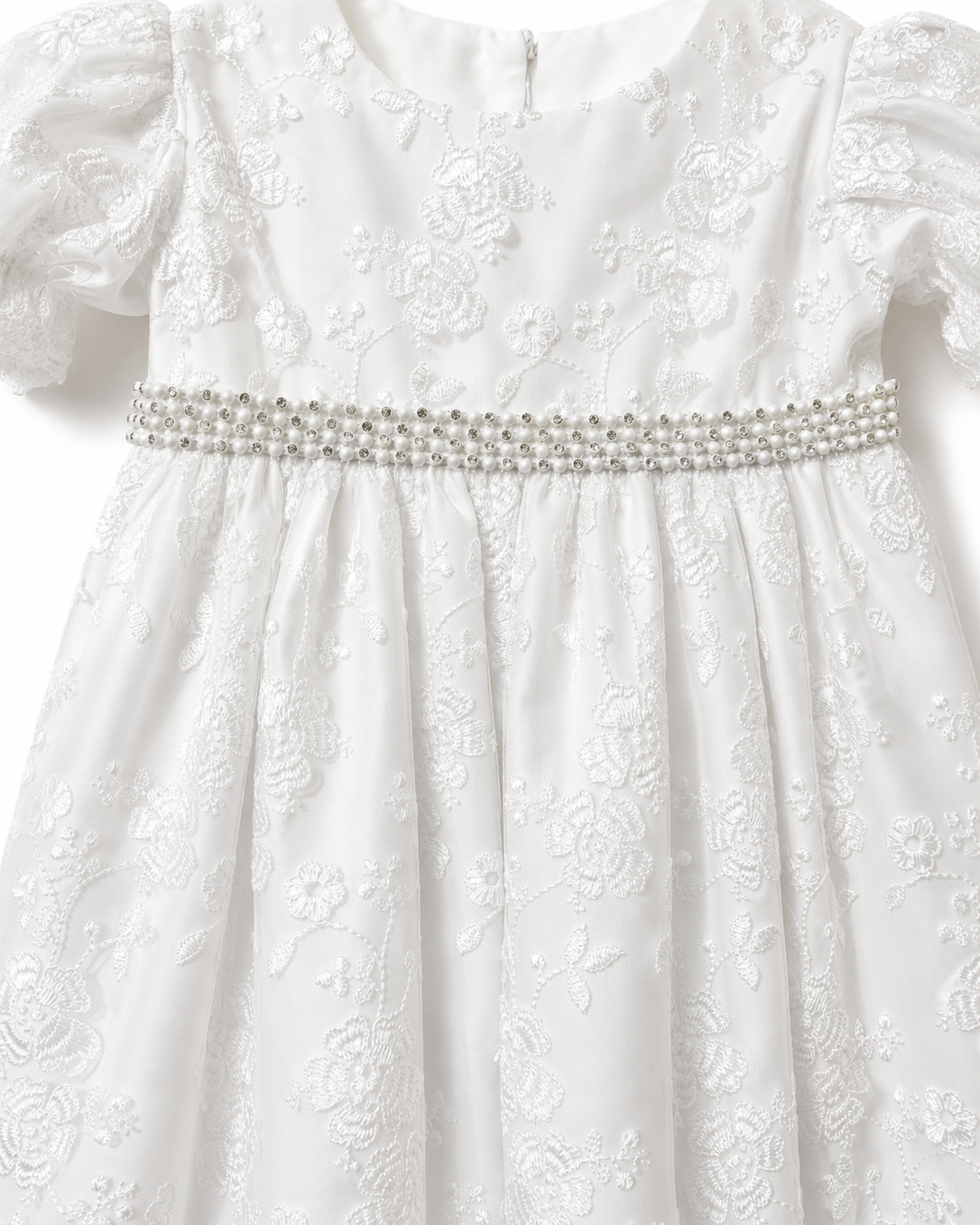 Close-up of the floral embroidery and pearl and diamante waist trim on the Visara christening gown
