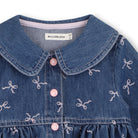 Close-up of Billieblush girls denim dress showing Peter Pan collar, pink buttons and bow print