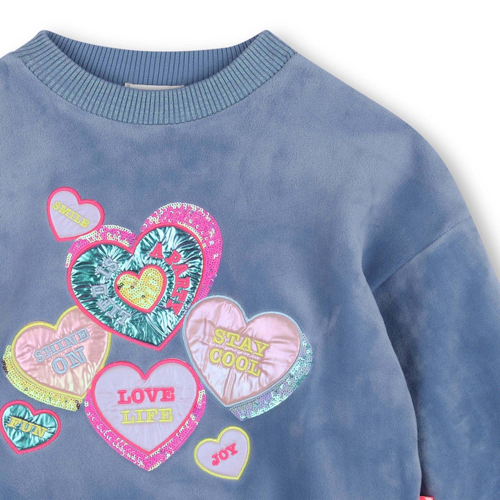 Close-up of Billieblush blue sweatshirt with multicoloured hearts