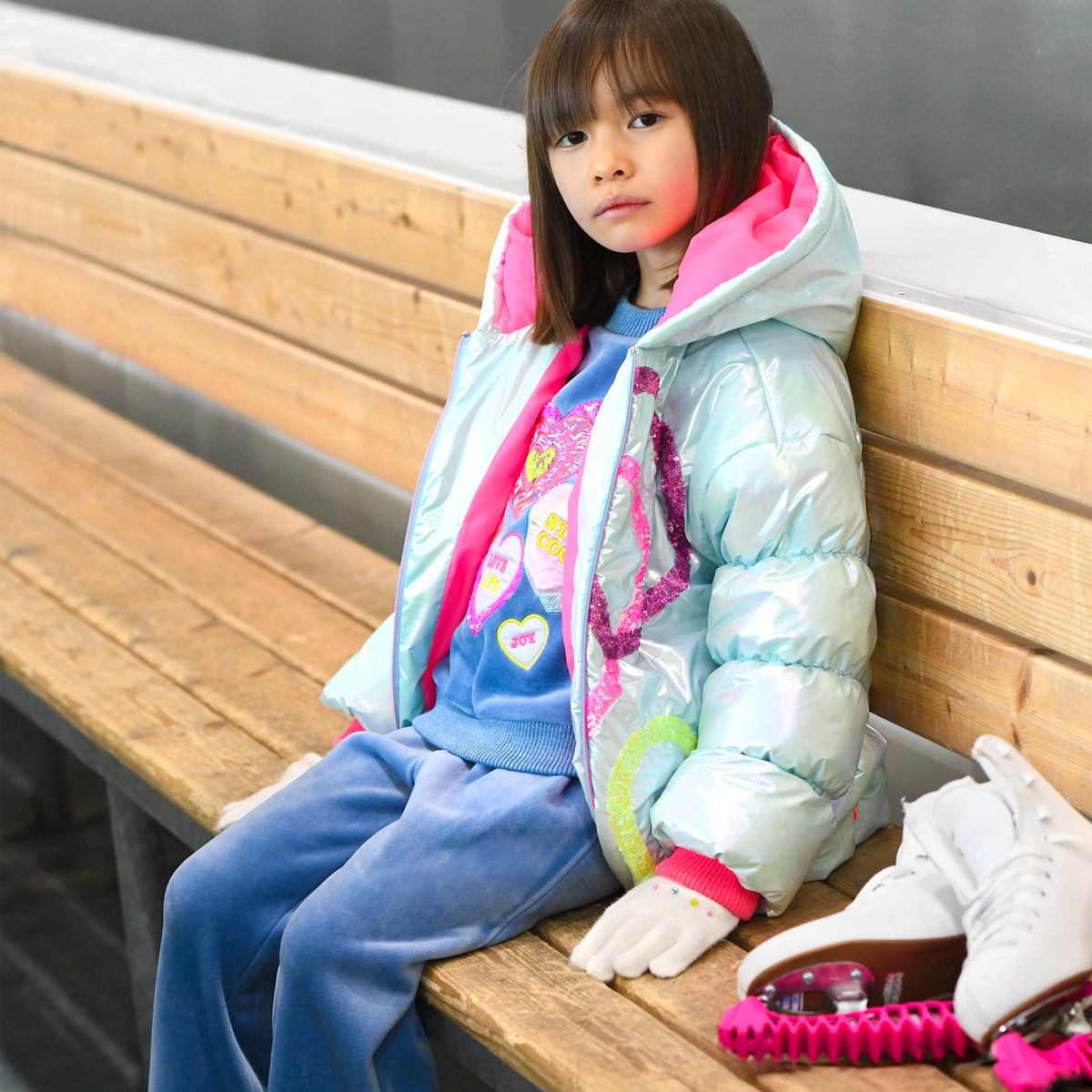 Girl wearing Billieblush blue heart sweatshirt with jeans and puffer jacket