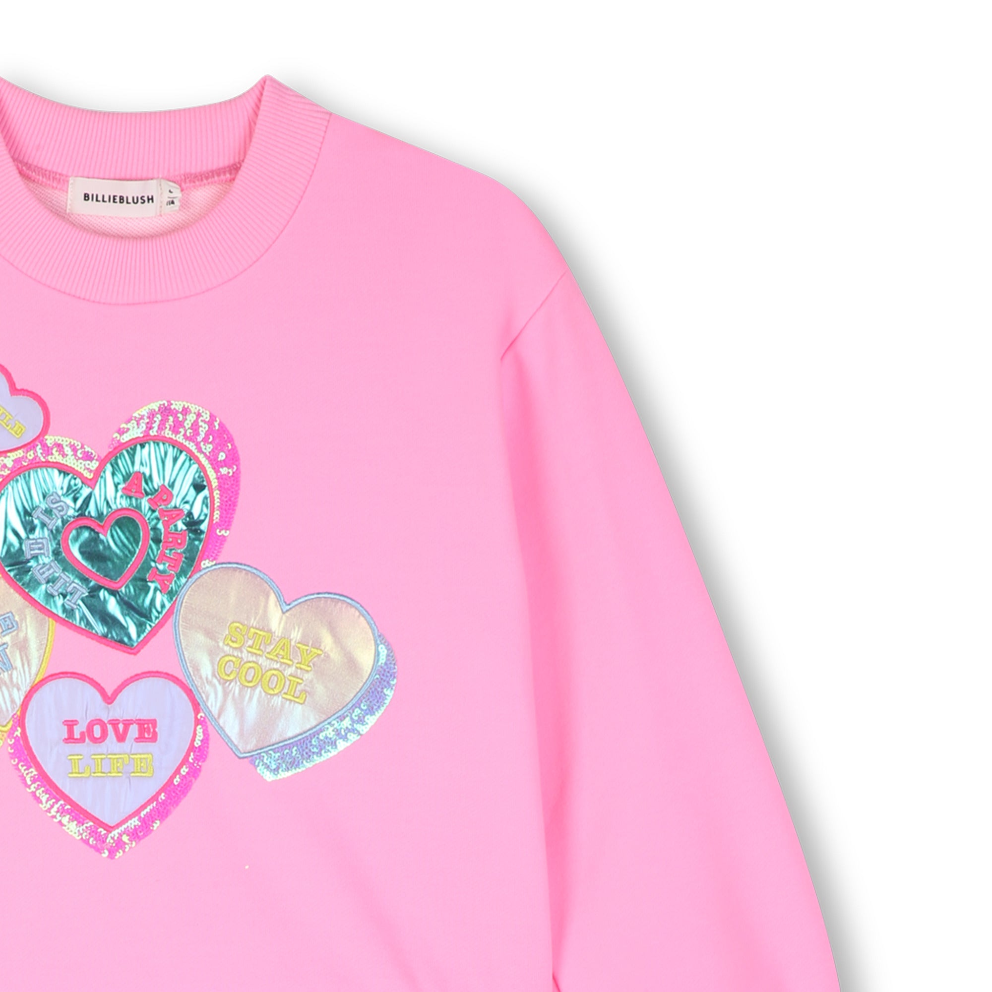 Close-up of colourful heart graphics on Billieblush pink sweatshirt dress