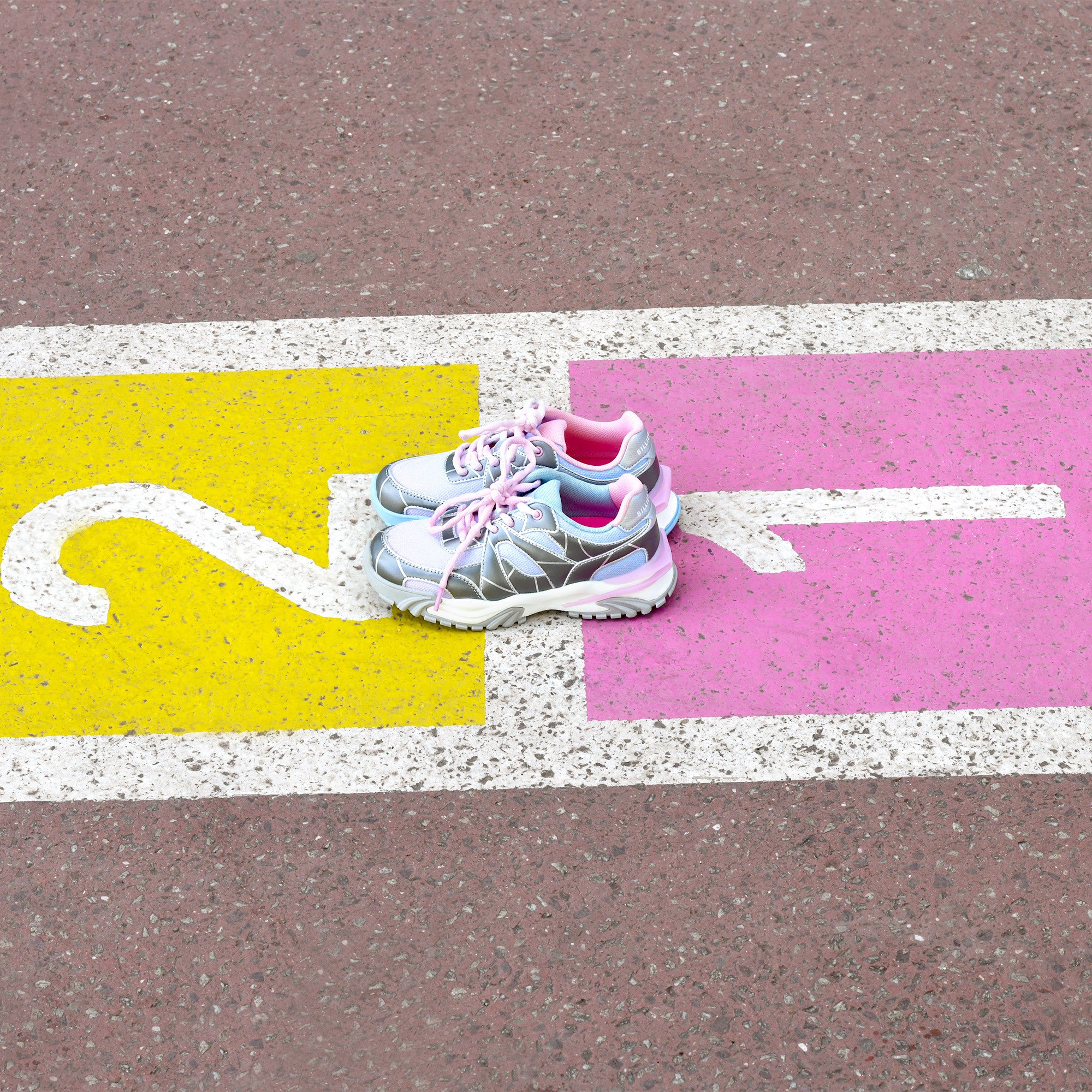 Billieblush girls metallic silver trainers photographed on colourful pavement