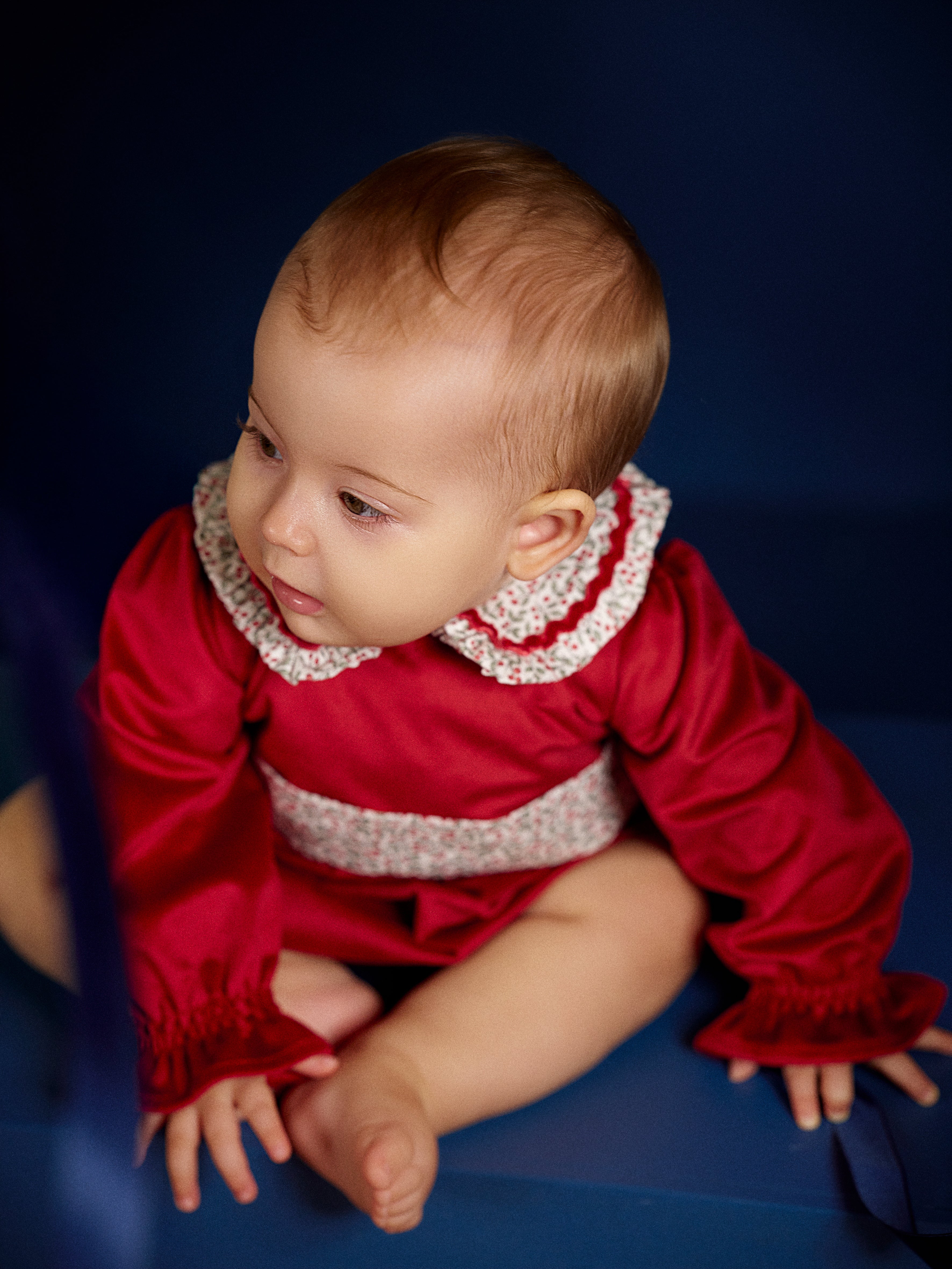 Baby girl wearing Deolinda Frosty red Christmas Day romper with floral collar