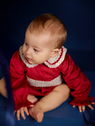 Baby girl wearing Deolinda Frosty red Christmas Day romper with floral collar