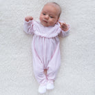 Baby girl wearing Emile et Rose Maddy pink velour babygrow lifestyle view