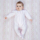 Baby girl wearing Emile et Rose Madeleine pale pink velour babygrow