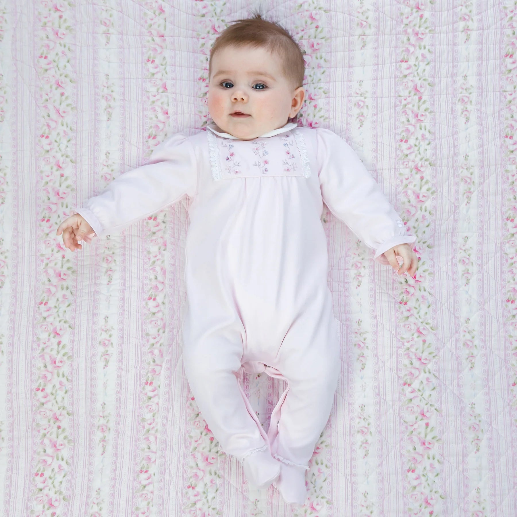 Baby girl wearing Emile et Rose Madeleine pale pink velour babygrow