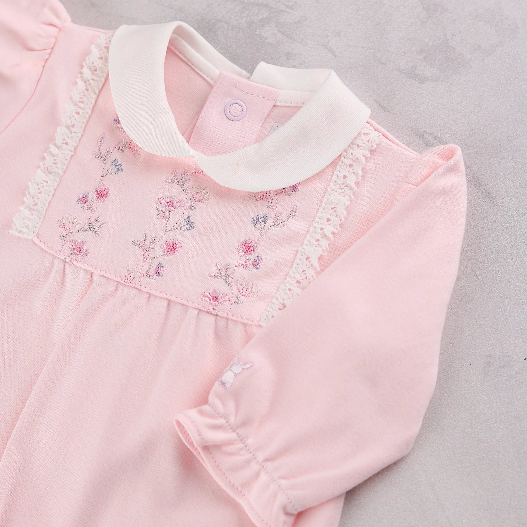 Baby girl wearing Emile et Rose Madeleine pale pink velour babygrow