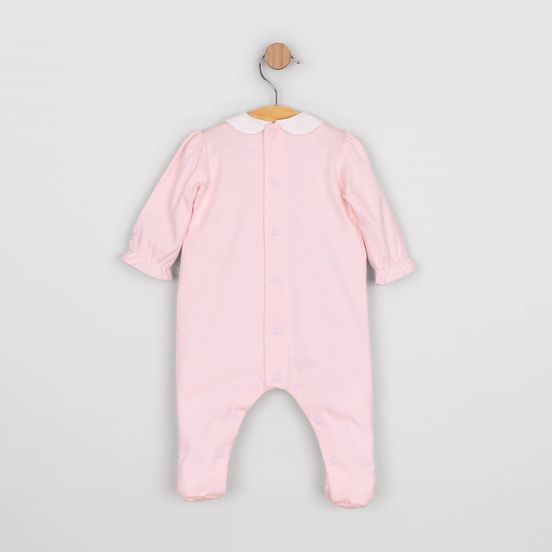 Baby girl in Emile et Rose Madeleine pink romper from the back